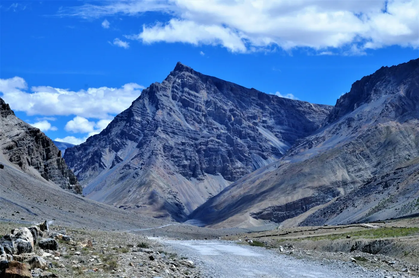 A barren high-altitude mountain valley and winding road in a cold desert, like Spiti